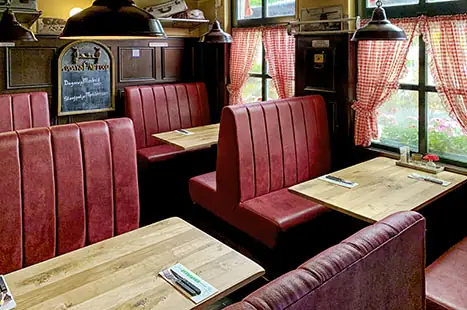 Rode bankjes en houten tafels in het restaurant