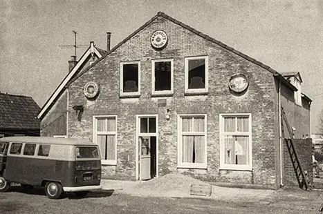 Oude foto van het pand met een Volkswagenbusje ervoor