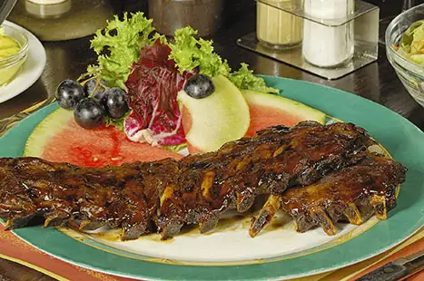 Spareribs met fruit en sla op een bord