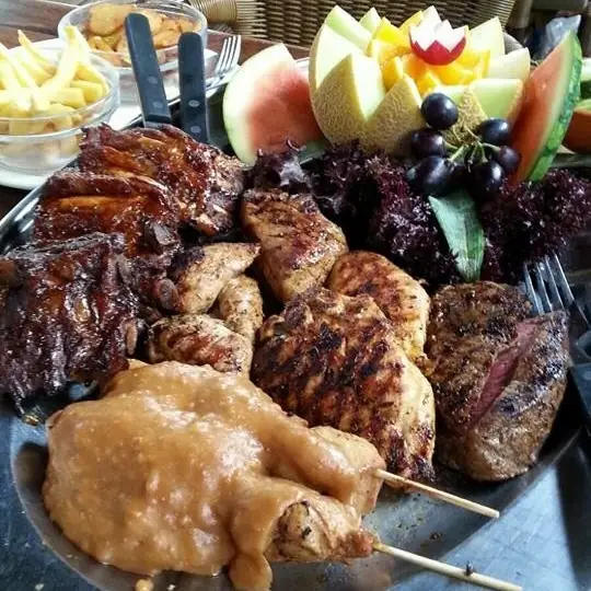 Schaal met gegrild vlees, saté en fruit