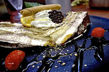 Dessert op een blauw bord met bessen