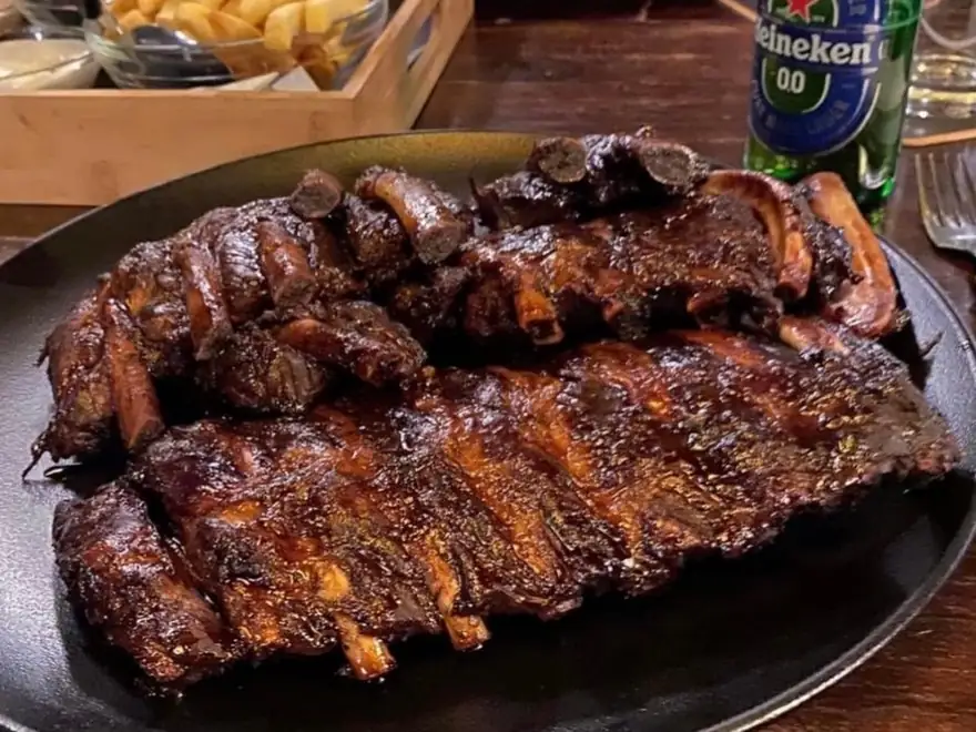 Spareribs op een bord met frites en een biertje