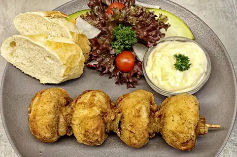 Gebakken champignons in bierbeslag op een spiesje, met saus tartaar