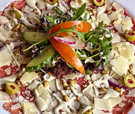 Rundercarpaccio met Parmezaanse kaas, olijven en rode ui